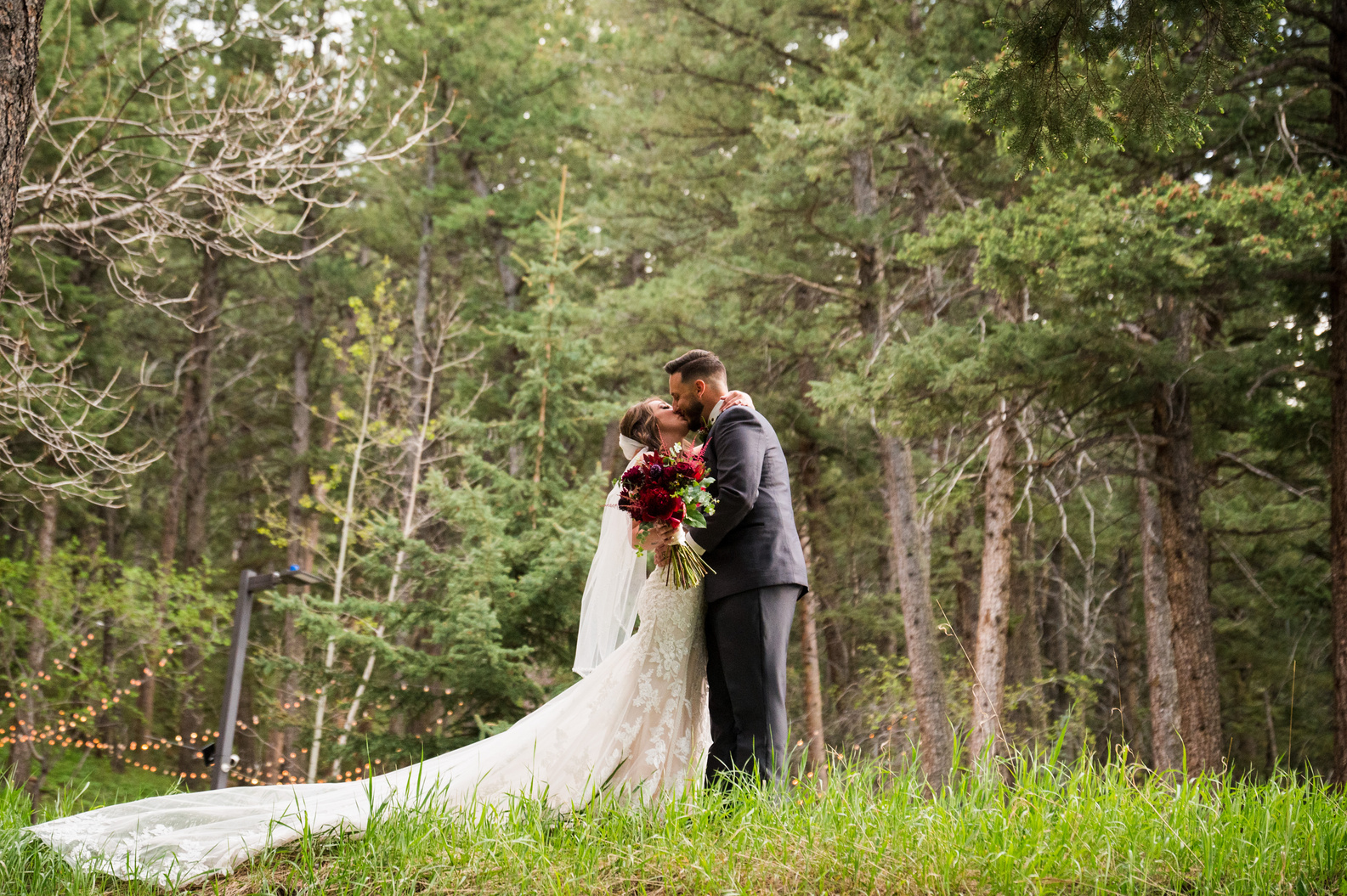 A bride and groom kissing in the woods at The Pines at Genesee in Genesee, Colorado.