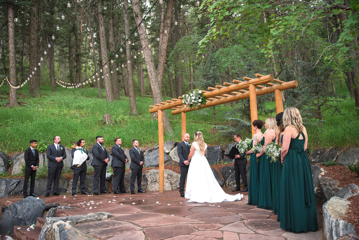 A wedding ceremony in the woods at The Pines at Genesee in Colorado, captured by Denver wedding photographer, Casey Van Horn.